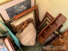 Various sized pictures and frames and wooden shelf