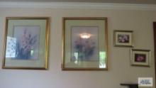 Two floral prints with gold frames and two small floral framed photographs